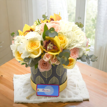Passion Garden All Occasion Collection, Yellow Gerbera, Rose Creme, Hydrangea, Cymbidium, Spray Rose, Eucalyptus, Black Box
